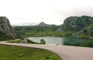 Rennradstrecke in Spanien mit einem See im intergrund und Bergen.