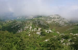 Rennradstrecke in Spanien mit Bergen, die in die Nebeldecke eintauchen.